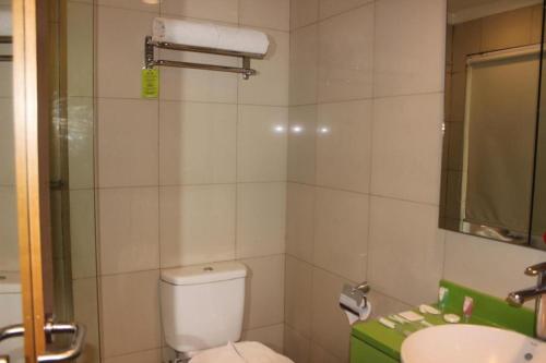 a small bathroom with a toilet and a sink at Pomelotel Patra Kuningan Jakarta in Jakarta