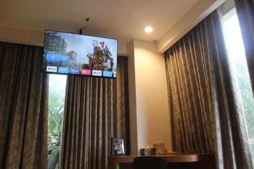 a room with a large screen in a hotel room at Pomelotel Patra Kuningan Jakarta in Jakarta