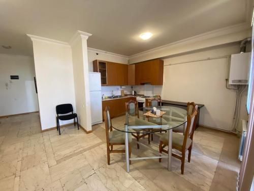 a kitchen and dining room with a glass table and chairs at Perfect Grin Point with fire-place in Aghk'ilisa