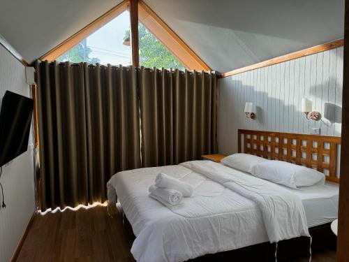 a bedroom with a bed with two towels on it at Morgen Resort24h in Ban Don