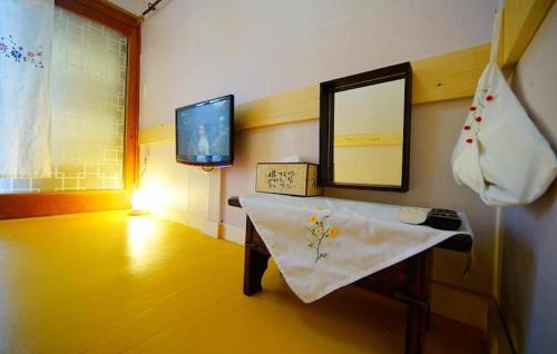 a room with a table and a mirror and a television at Jungdam in Jeonju