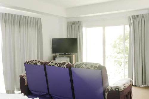 a living room with two chairs and a tv at Urban House 195 in Chiang Mai