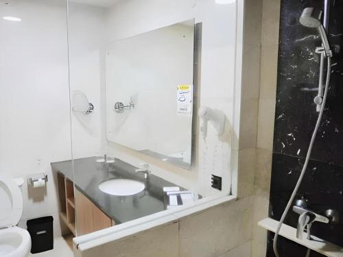 une salle de bain avec un lavabo et un miroir dans l'établissement Indoluxe Hotel Jogjakarta, à Kejayan