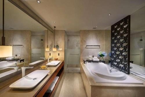 a large bathroom with two sinks and a tub at Hotel Tentrem Yogyakarta in Yogyakarta