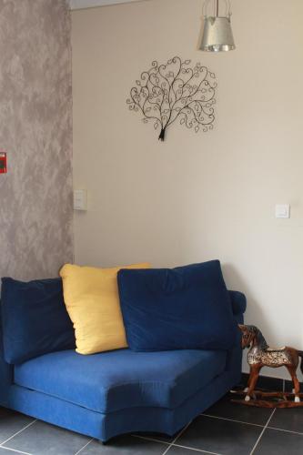 a blue couch in a living room with a tree on the wall at A l'Aube des Volcans in Charbonnières-les-Vieilles