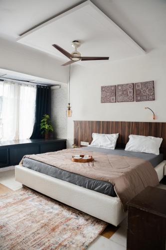 a bedroom with a large bed and a ceiling fan at Pearl Palace 4-Bedrooms Villa by Spacez with Private Theatre & Terrace in Mumbai