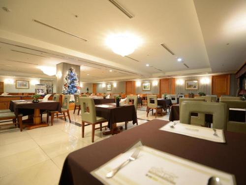 a restaurant with tables and chairs and a christmas tree at Onyang Hot Spring Hotel in Asan