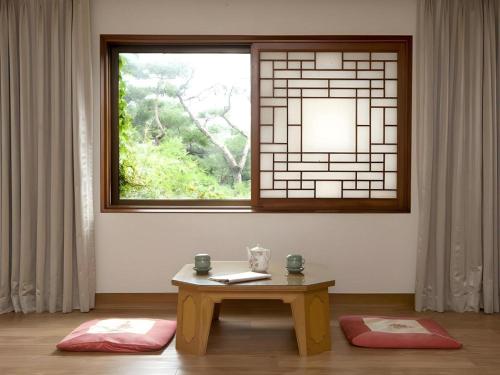 a room with a table in front of a window at Onyang Hot Spring Hotel in Asan