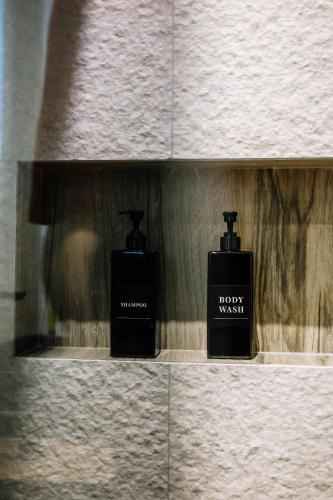 two bottles of soap on a shelf in a wall at Karma Chic&Style Intera Villa in Korçë