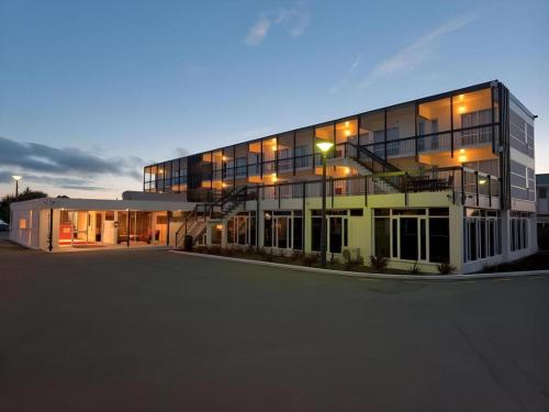a large building with a parking lot in front of it at The Riccarton Hotel in Christchurch