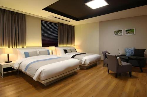 a hotel room with two beds and a desk at KT&G Sangsangmadang Chuncheon Stay (Korea Quality) in Chuncheon