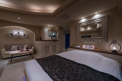 a bedroom with a large bed and a couch at ホテル フェスタ 横須賀 in Yokosuka