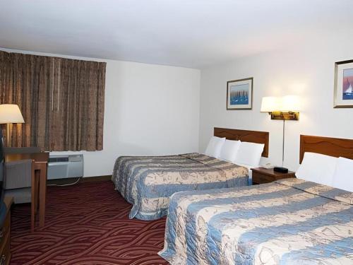 a hotel room with two beds and a desk at Econo Lodge Inn & Suites in Stevens Point