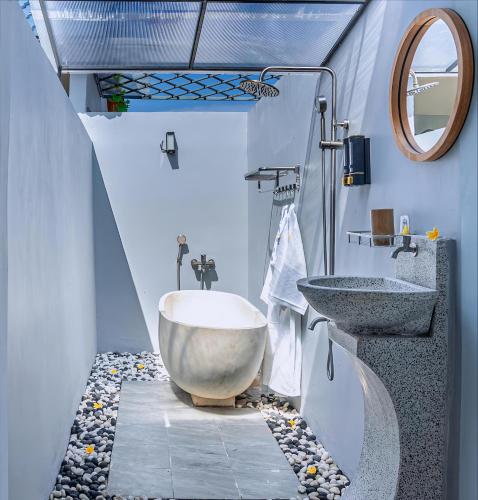 a bathroom with a large tub and a sink at Kotoa Villa 68 in Nusa Dua