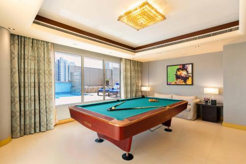 a pool table in a living room with a view at The K Hotel in Manama