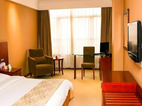 a hotel room with a bed and a table and chairs at Super 8 Hotel Quanzhou Xinchezhan Branch in Quanzhou