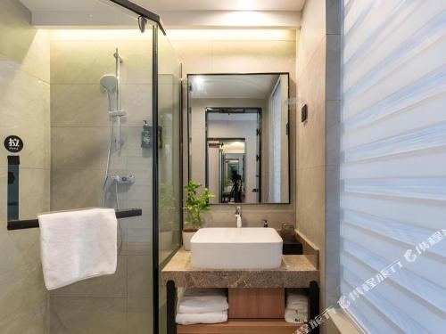 a bathroom with a sink and a shower at GreenTree Inn Jinan Quancheng Hotel in Jinan