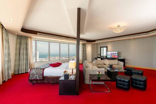 a hotel room with a bed and a couch at The K Hotel in Manama