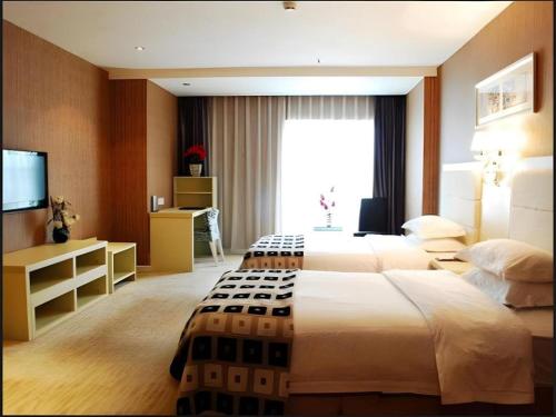 a hotel room with two beds and a television at Chengdu Huadu Times Hotel in Chengdu
