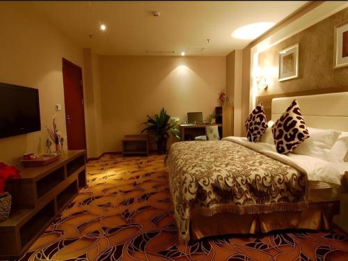 a hotel room with a bed and a flat screen tv at Chengdu Huadu Times Hotel in Chengdu