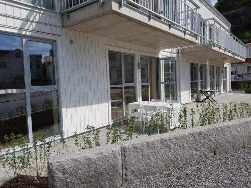 un edificio con porche con mesa y sillas en Fjällbacka en Fjällbacka