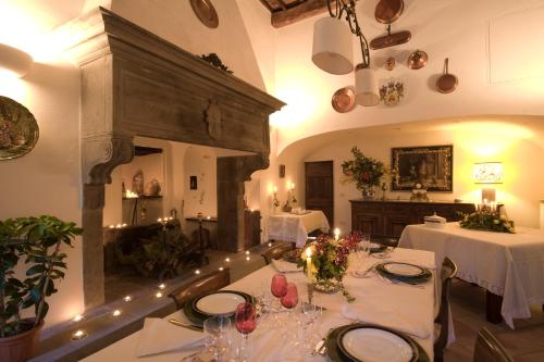 a dining room with two tables with white tableclothsurrencyangering at Palazzo Torriani in Marradi