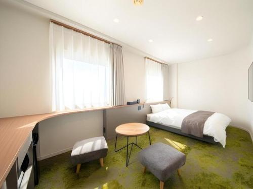 a bedroom with a bed and a table and chairs at Hotel Anesis Seto-Ohashi in Marugame