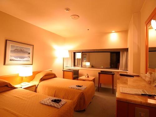a hotel room with two beds and a large window at Gunma Royal Hotel in Maebashi