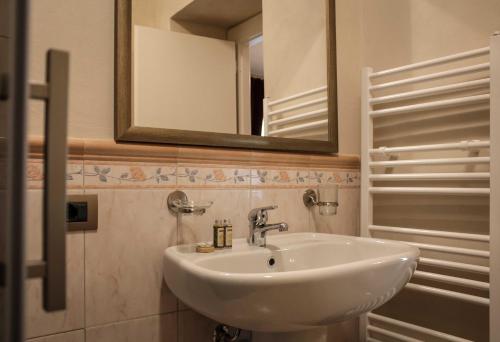 a bathroom with a white sink and a mirror at Le Stanze Della Musica in Borgomale
