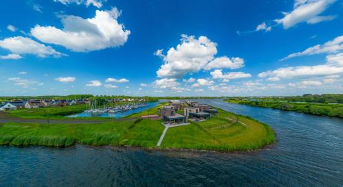 an island in the middle of a river with houses at Premium Island Villas, Parc Maasresidence Thorn in Thorn