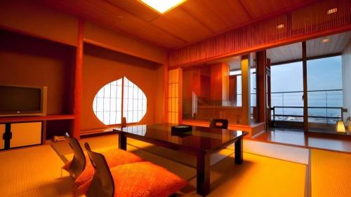 a living room with a table and a couch at Kannawa Onsen Hotel Sansuikan in Beppu