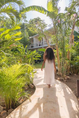 a little girl in a white dress walking down a sidewalk at Casa Cactus Buenavista in Bacalar