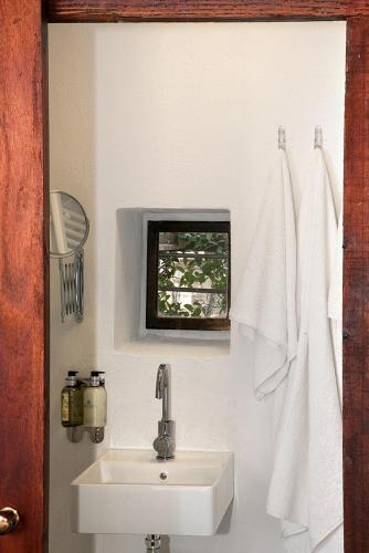 a bathroom with a white sink and a window at The Pelion Manifesto 2 in Agios Georgios Nilias
