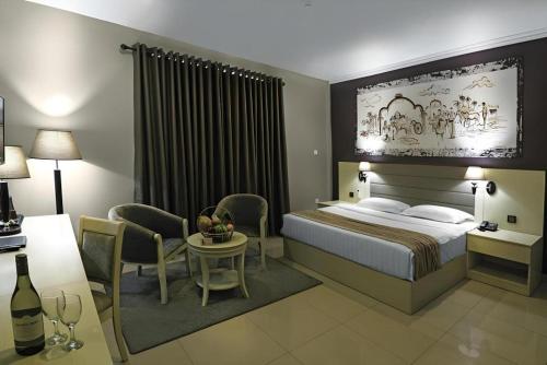 a hotel room with a bed and a table and chairs at Tilko Jaffna City Hotel in Jaffna