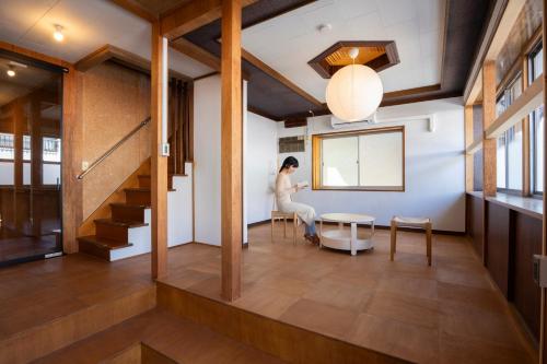 a woman sitting at a table in a room at Roopt松本中央 in Matsumoto