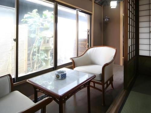 a living room with a coffee table and a chair at Suigetsurou Hotel in Takaoka