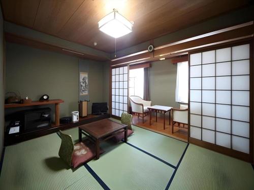 a room with a table and chairs and a dining room at Suigetsurou Hotel in Takaoka