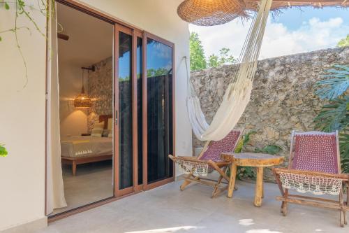 a room with a patio with chairs and a bed at Casa Cactus Buenavista in Bacalar