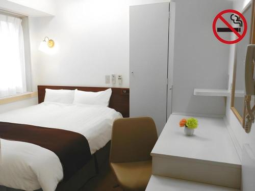 a bedroom with a bed and a no parking sign at Hotel Annex Check In Shimbashi in Tokyo