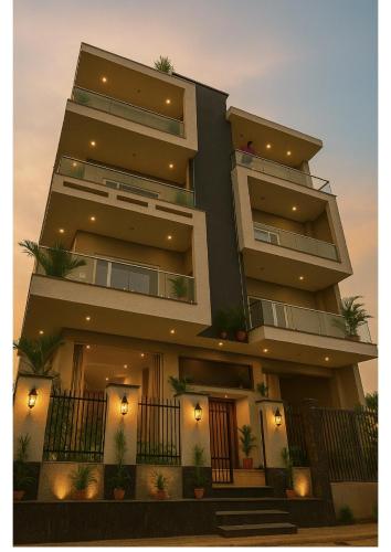 un edificio alto con plantas delante en Hotel Stayzzy Bloom, en Noida
