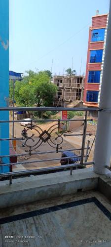 a bench on a balcony with a view of a park at Hotel Aishwarya New Digha I Near Amrabati Park in Digha