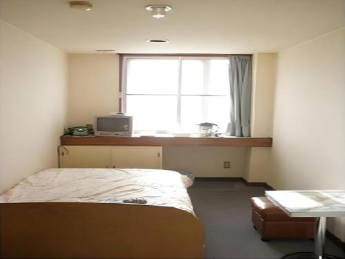 登別市にあるDate Business Hotel Castleの窓の前にベッドがある寝室