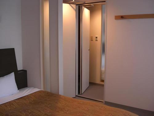 a room with a bed and a sliding glass door at Hirata Maple Hotel in Izumo