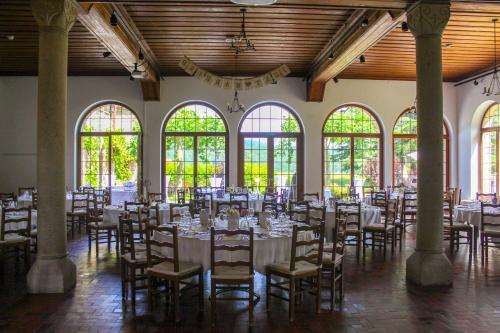 Un salón de banquetes con mesas, sillas y ventanas. en Crêt-Bérard, en Puidoux