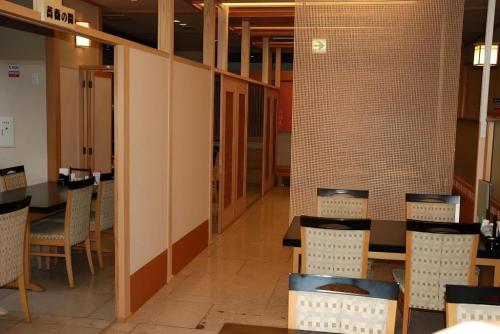 a dining room with tables and chairs and brick walls at Albert Hotel in Akita