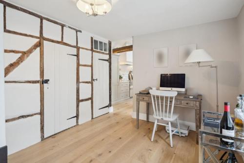 a room with a desk with a computer and a window at Historic terrace house in Old Amersham in Amersham