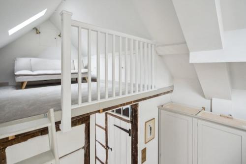 a white staircase in a room with a couch at Historic terrace house in Old Amersham in Amersham