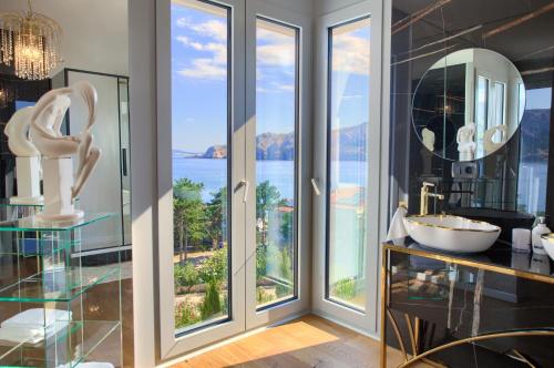 a bathroom with a large window with a view of the water at The Oscar in Baška