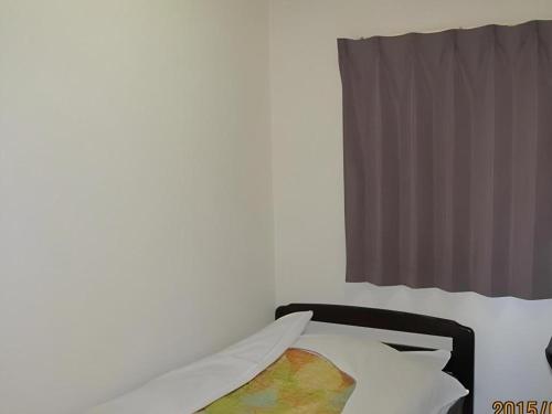 a bedroom with a white bed with a window at Business Hotel Oise in Nagoya