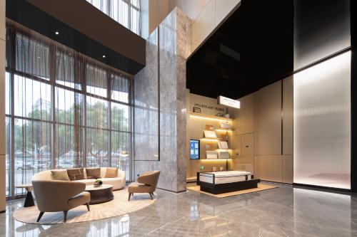 Un vestíbulo con un sofá y sillas y una mesa. en Atour Hotel Wenling Zeguo Lingyue Plaza, en Wenling